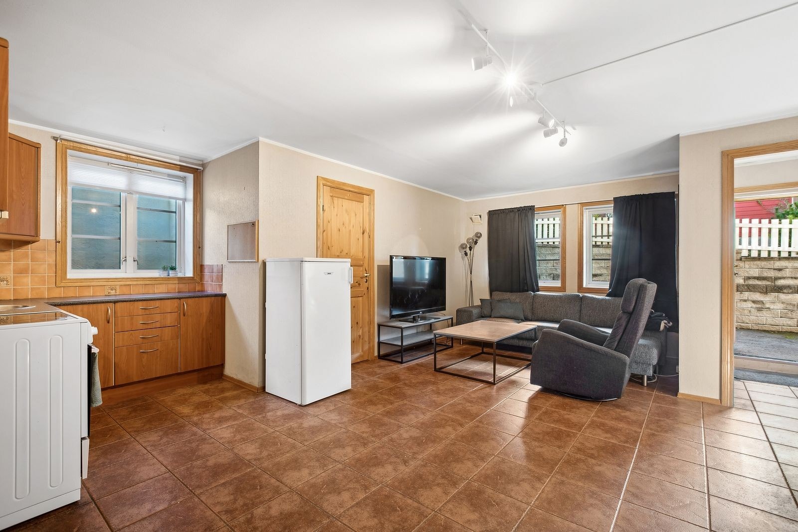 Romslig allrom med praktisk åpen kjøkken/stue-løsning med fliser på gulv og gulvvarme. Kjøkkeninnredning med glatte fronter og laminat benkeplate. Rommet byr på god plass til både spisebord og sofagruppe. Galleribilde