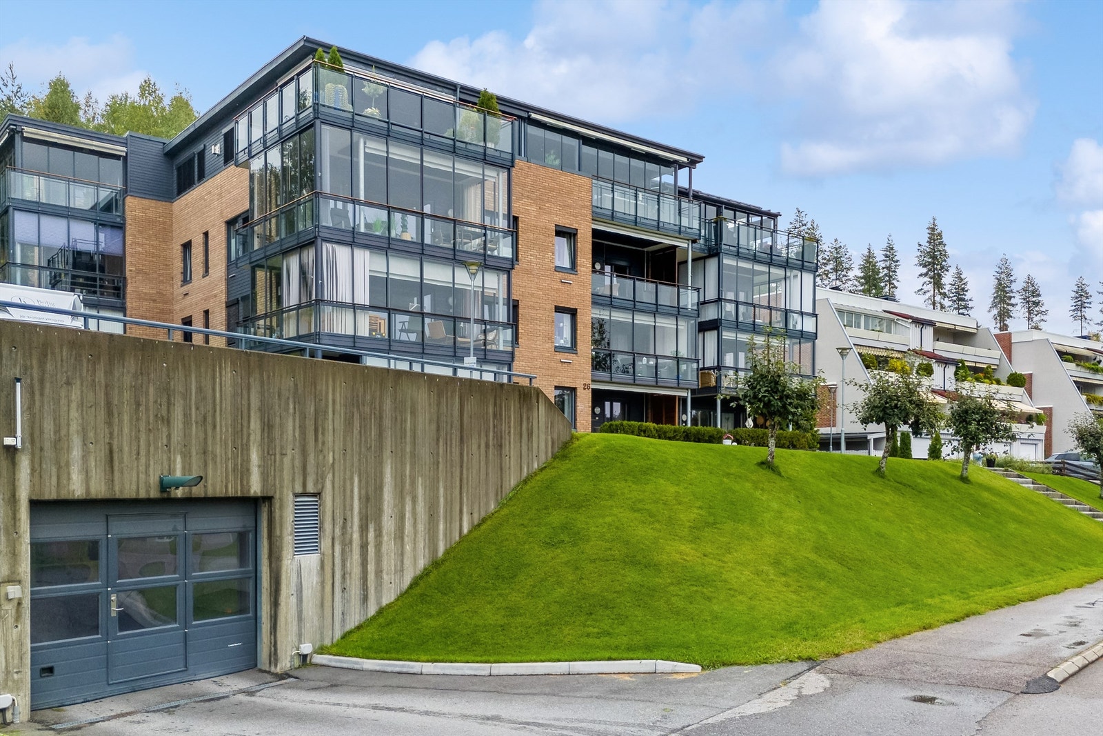Leiligheten ligger i 1. etasje i ei opphøyd boligblokk sett fra veien. Direkte adkomst fra garasjeanlegget via heis/trapp opp til 1. etasje Galleribilde