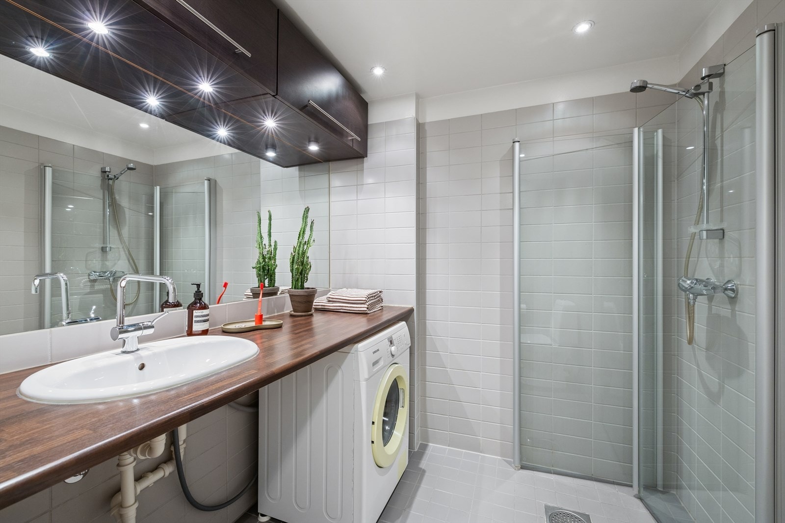 Leiligheten har et romslig bad og er flislagt i moderne og tidløs stil. Galleribilde