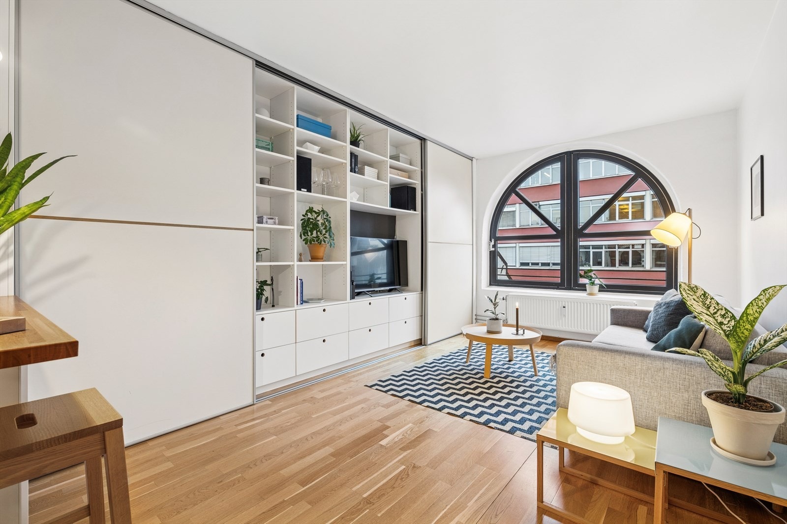 Lys og romslig stue med smarte integrerte oppbevaringløsninger. Galleribilde