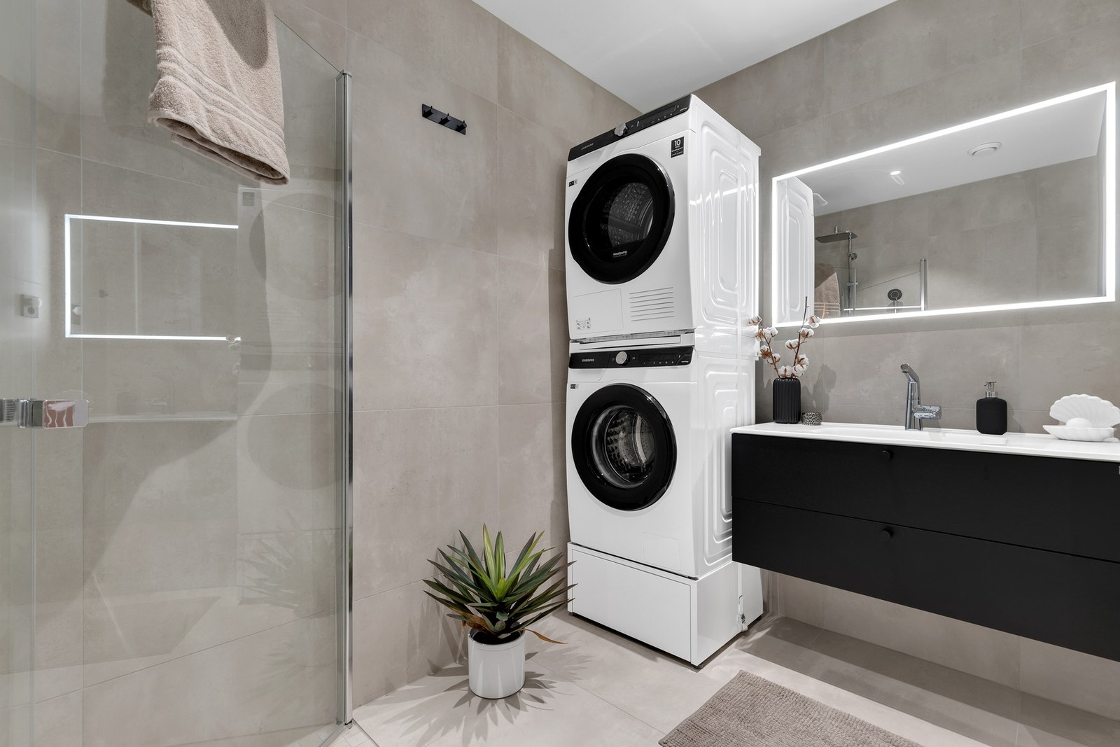 Dusjnisje med innfellbare dører, vegghengt toalett og opplegg for vaskemaskin/tørketrommel. Galleribilde