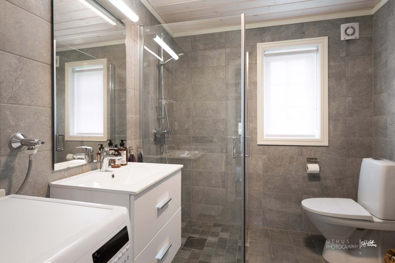 Flislagt bad med servantseksjon, wc, dusjhjørne, samt opplegg for vaskemaskin. Galleribilde