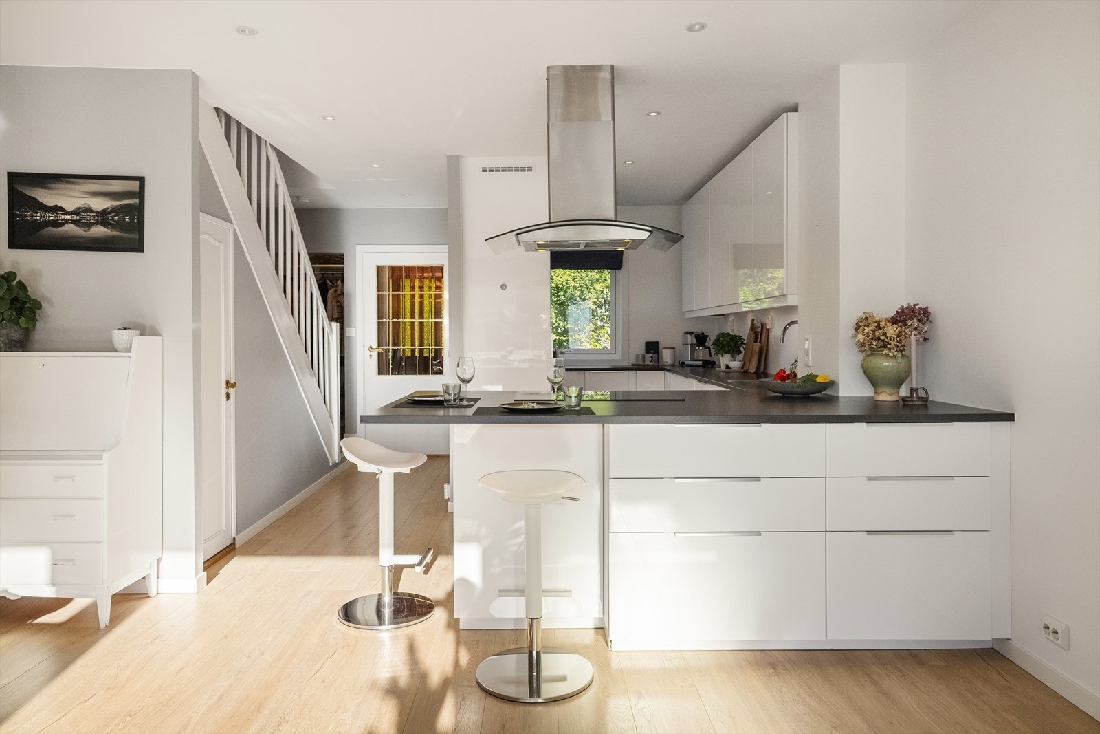 Her finner du et tidløst og pent kjøkken med lyse, høyglans fronter. Galleribilde