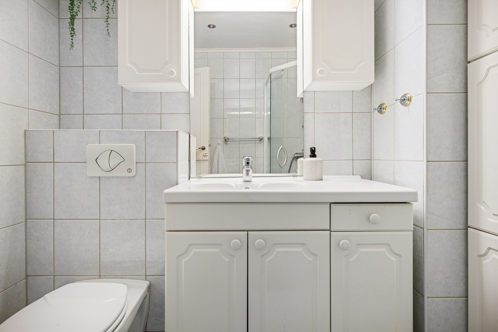 Videre er det innredet med vegghengt toalett, dusjhjørne, servant med møblement, speil og belysning. Galleribilde