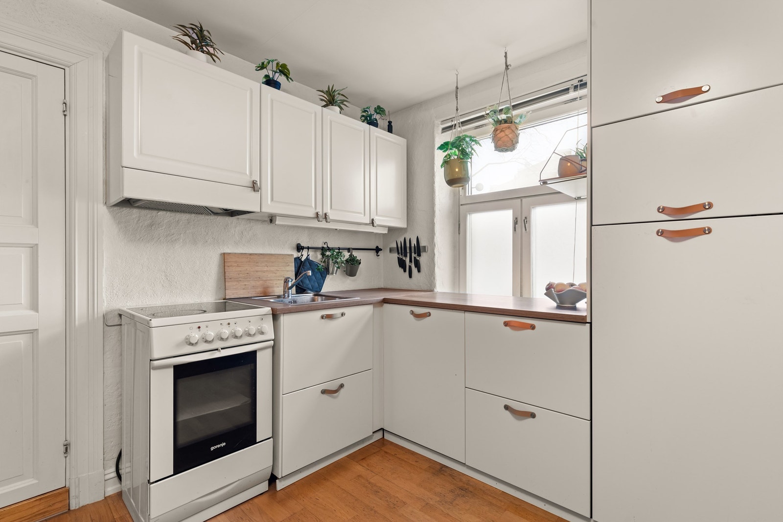 Tidløst og moderne kjøkken med lyse, slette fronter fra 2017, benkeplate av laminat og oppvaskkum i rustfritt stål. Galleribilde