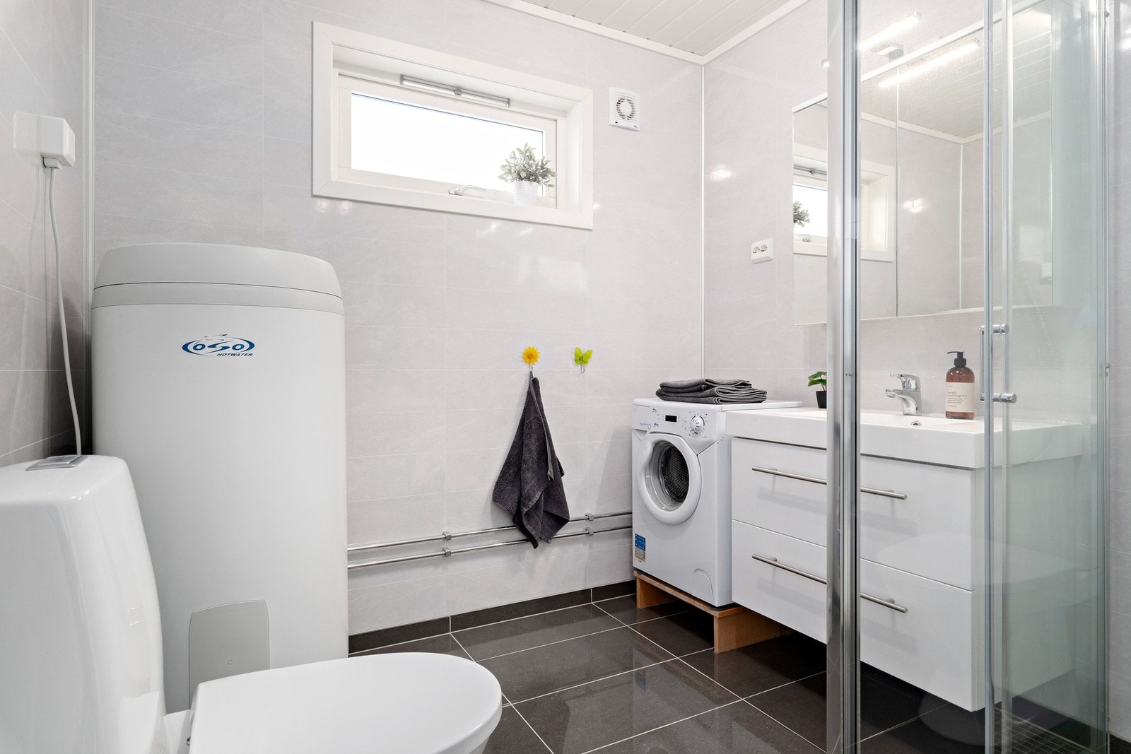 Delikate våtromsplater på veggflater, varmekabler og fliser på gulv. Legg merke til avtrekksvifte og klaffventiler på vindu. Varmtvanns tank på ca 200l. Galleribilde