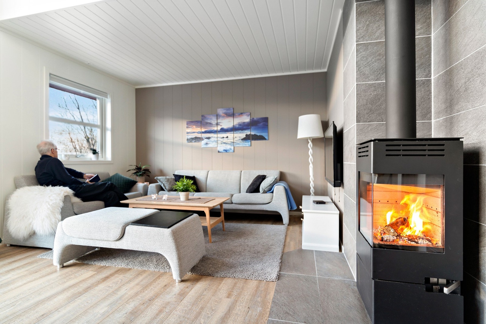 Den flotte vedovnen har glassfronter på to sider, legg også merke til de flotte flisene på vegg og under ildsted. Høy trivselsfaktor. Galleribilde