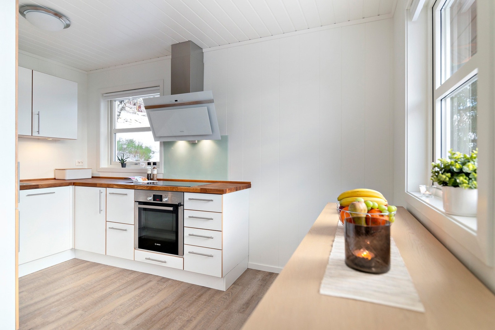 Kjøkkenet har induksjonstopp og komfyrvakt, elegant ventilator, integrert oppvaskmaskin, kjøl/fryseskap og glassplater ved koketopp og oppvaskkum. Galleribilde