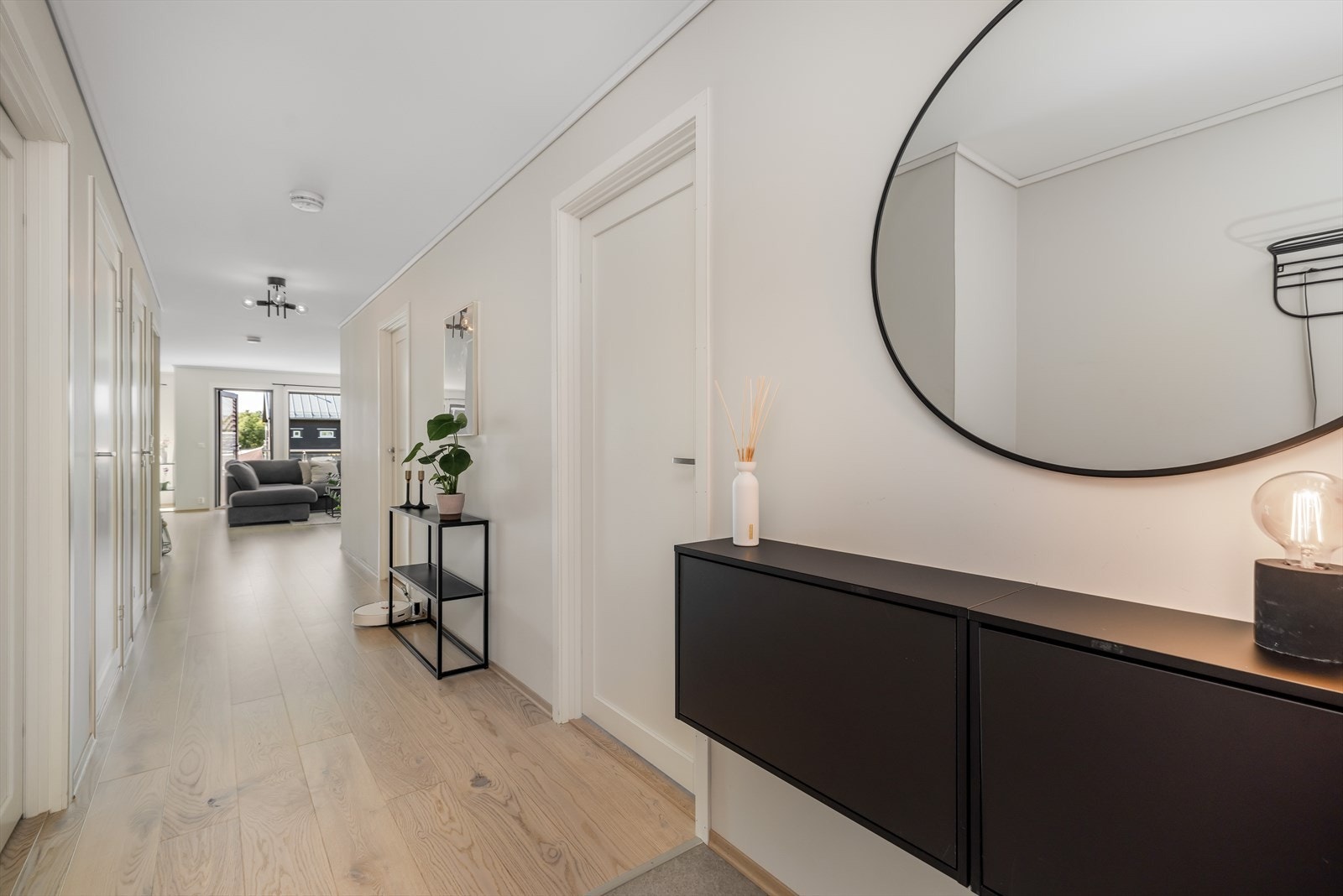 Gangareal i åpen løsning med boligens entré og stue. Gangen pen, enstavs eikeparkett på gulv. Galleribilde