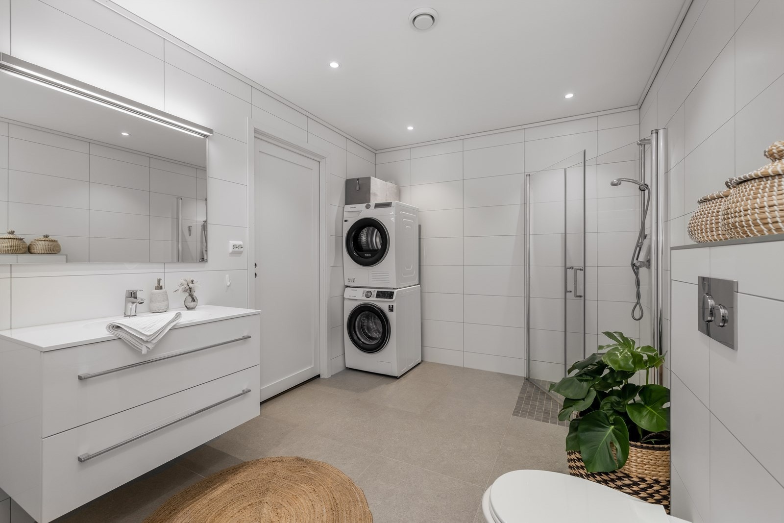 Delikat bad av god størrelse, med varmekabler i gulv. Badet er utstyrt med vegghengt toalett og opplegg for vaskemaskin og tørketrommel. Galleribilde