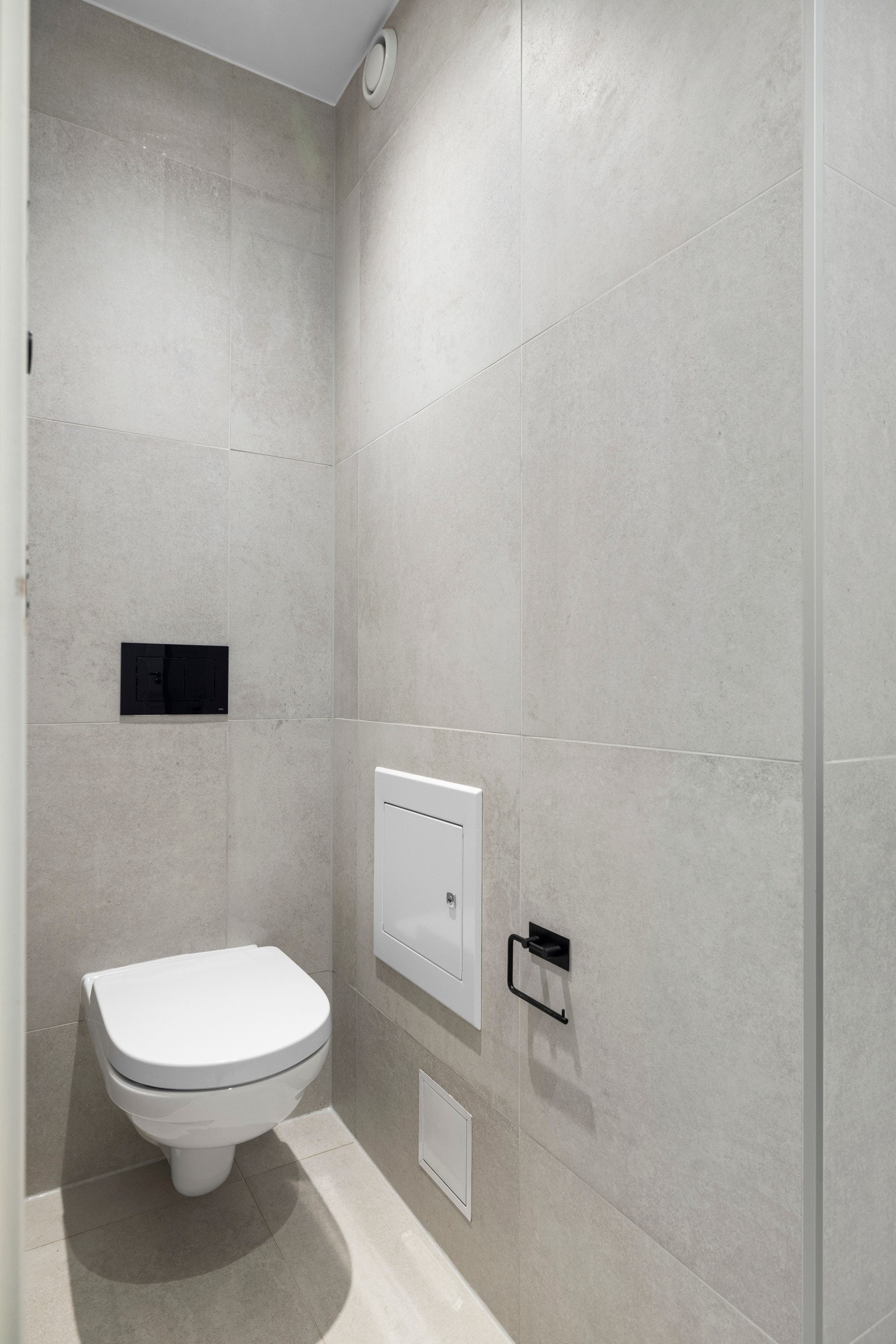 - Bad har vegghengt toalett med innebygd sisterne kasse og servant på vegghengt servantskap - Galleribilde