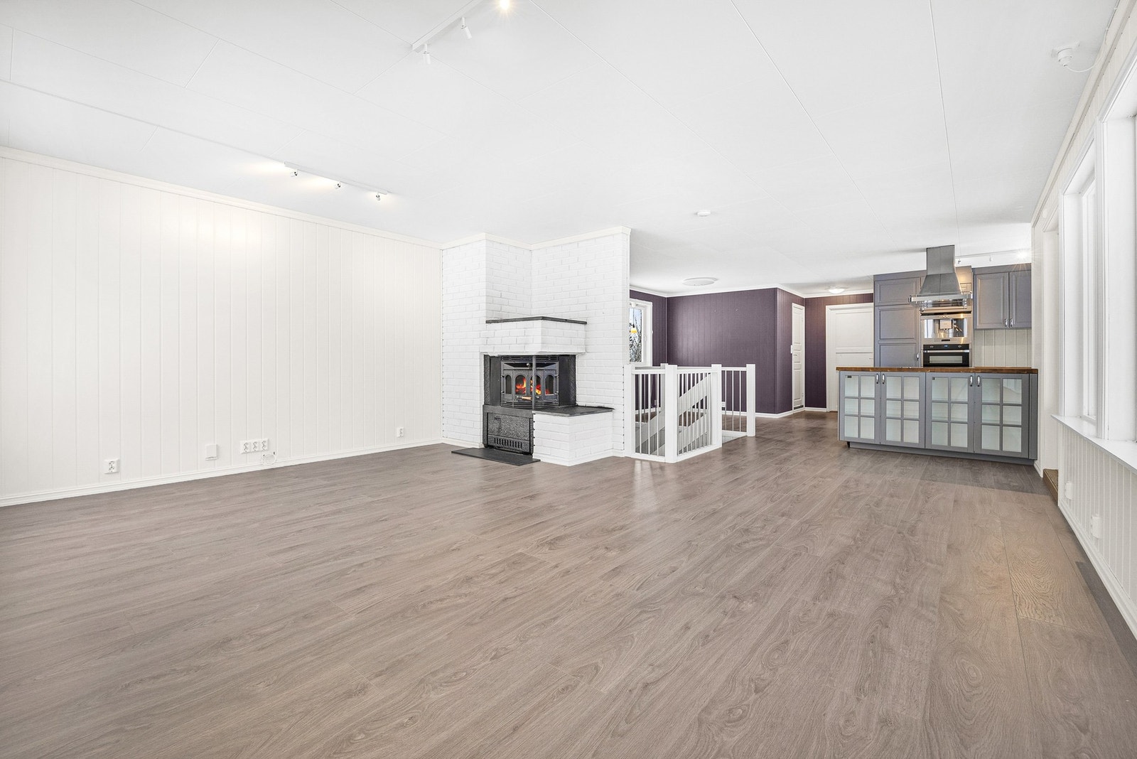 Vedovnen står sentralt i stuen. Det er varmepumpe i trapperommet. Galleribilde