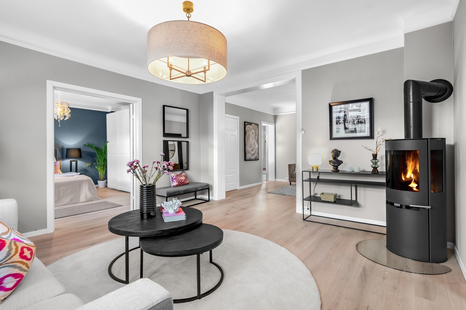 Stuen har peis, luftig takhøyde på drøye 2,7 meter, gråmalte, glatte vegger og enstavs parkett som er lagt sømløst mellom sonene. Galleribilde