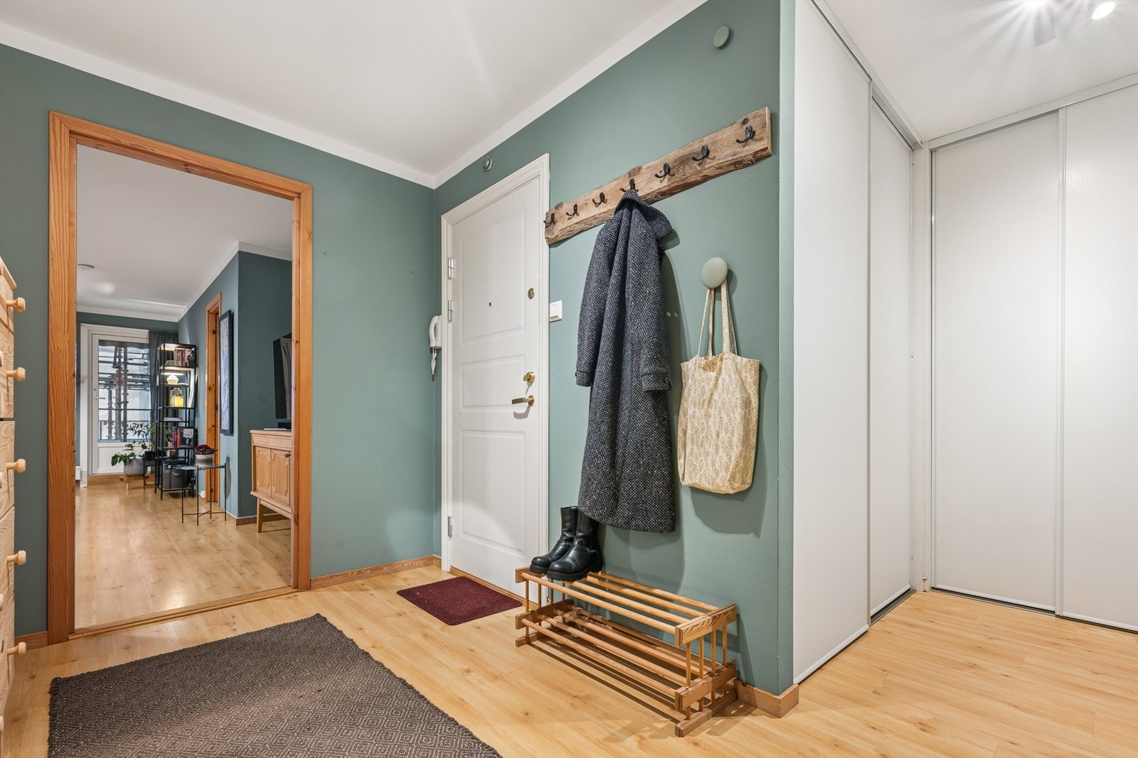 En romslig entré ønsker deg velkommen inn i leiligheten. Her får du godt med oppbevaringsplass i en stor skyvedørsgarderobe. Galleribilde