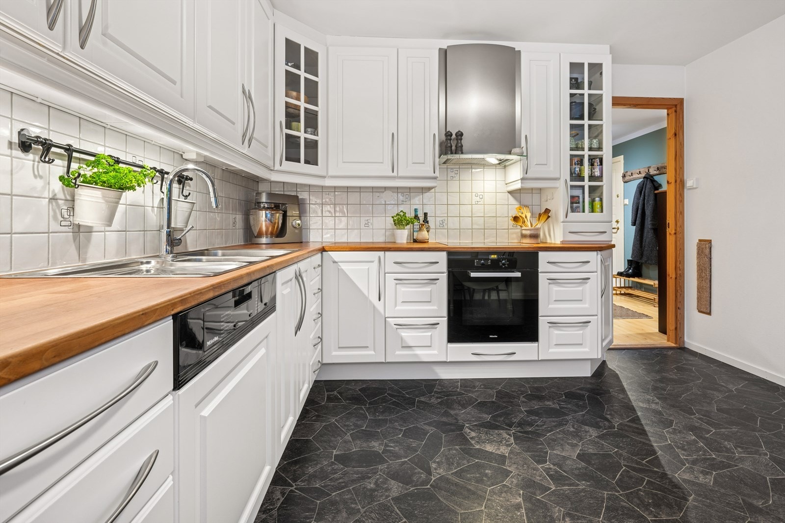 Innredning har hvite profilerte fronter og noen overskap med glassfronter og laminat benkeplate. Galleribilde