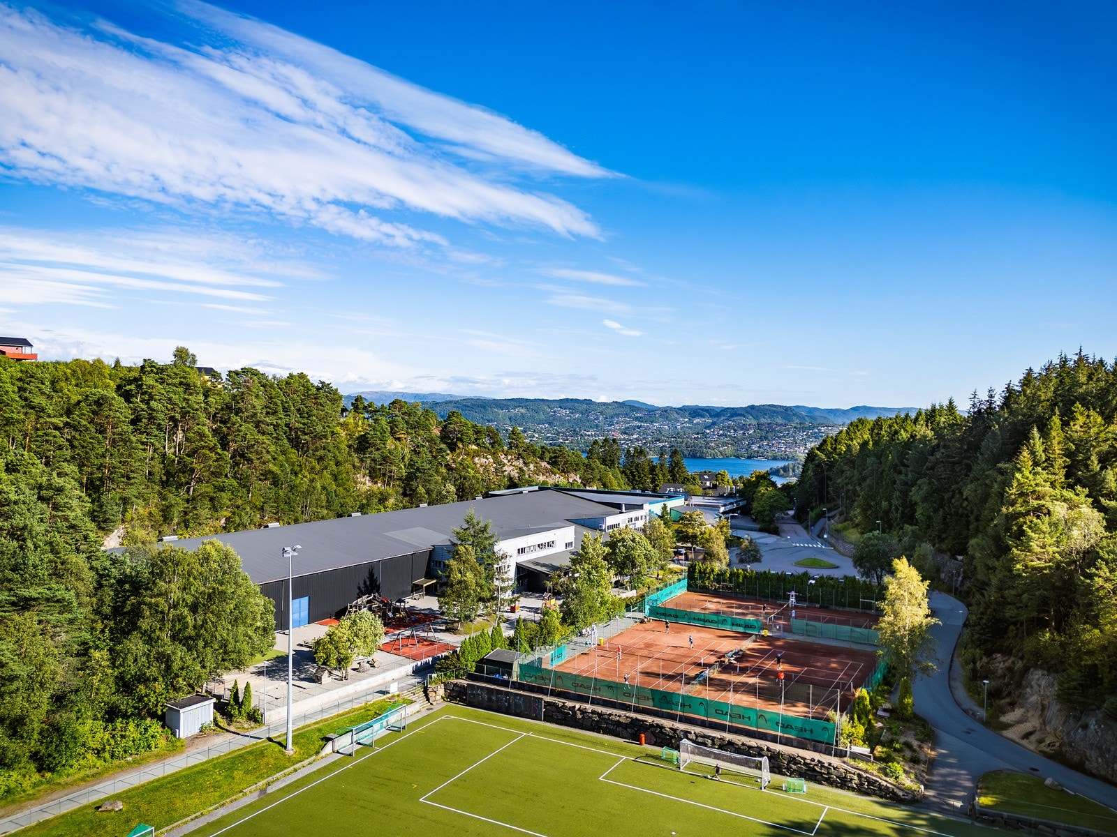 Idrettsplass like bak boligen med kunstgressbane og tennisbaner, samt idrettshall, racketsenter og treningssenter. Galleribilde