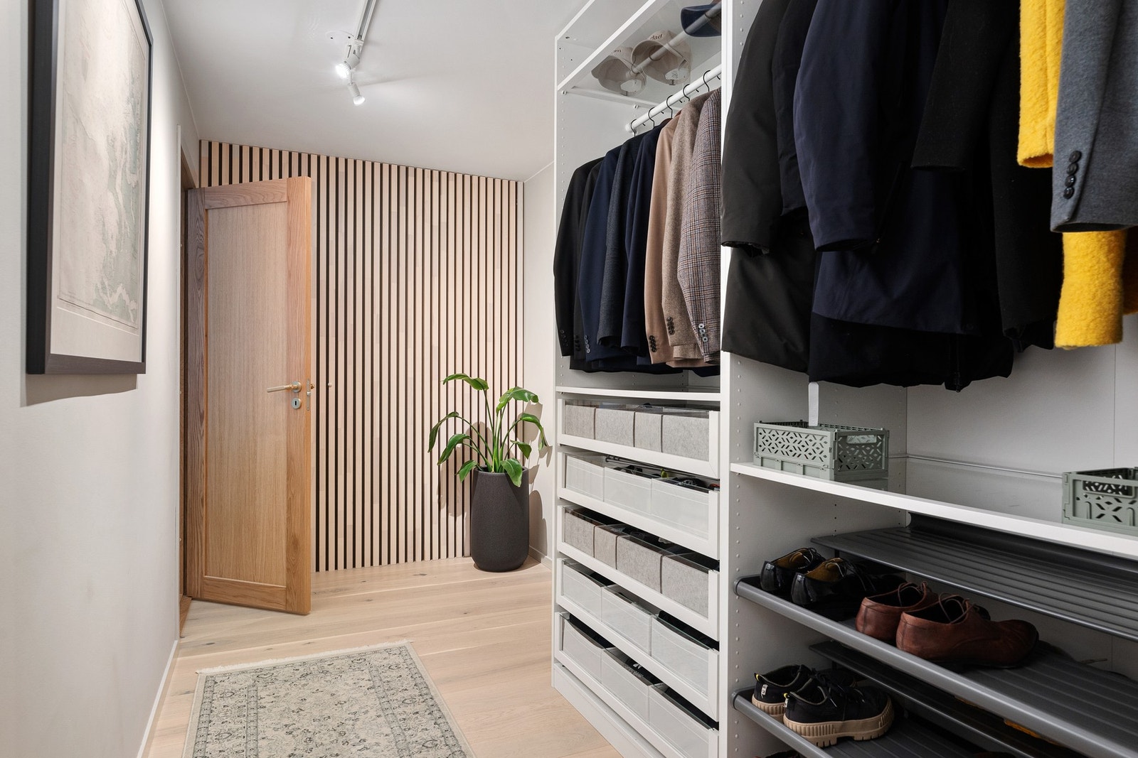 Romslig garderobe med smarte oppbevaringsmuligheter for klær og sko. Galleribilde