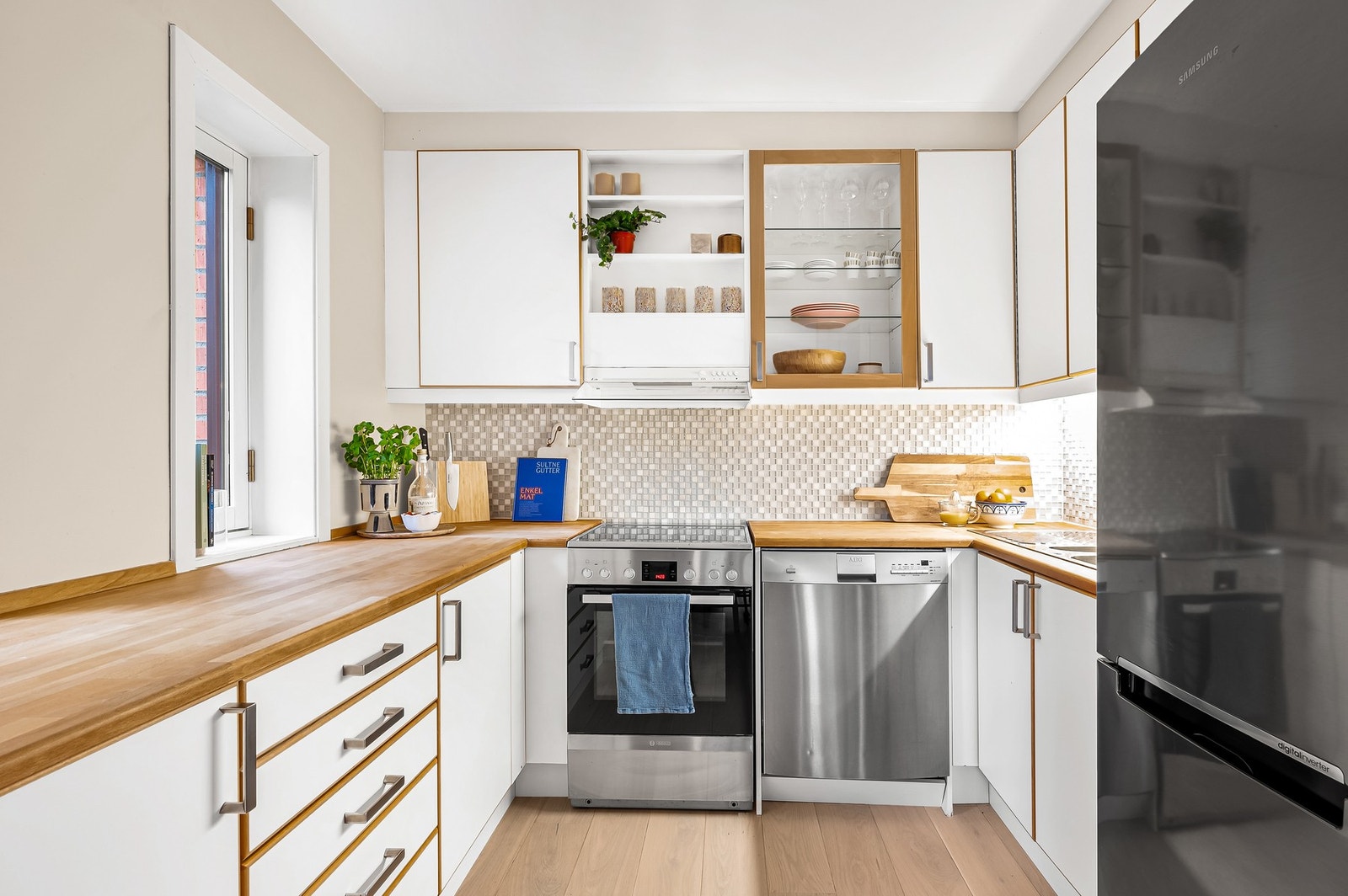 Kjøkken i lyst og tidløst design. Godt med skap og benkeplass. Galleribilde