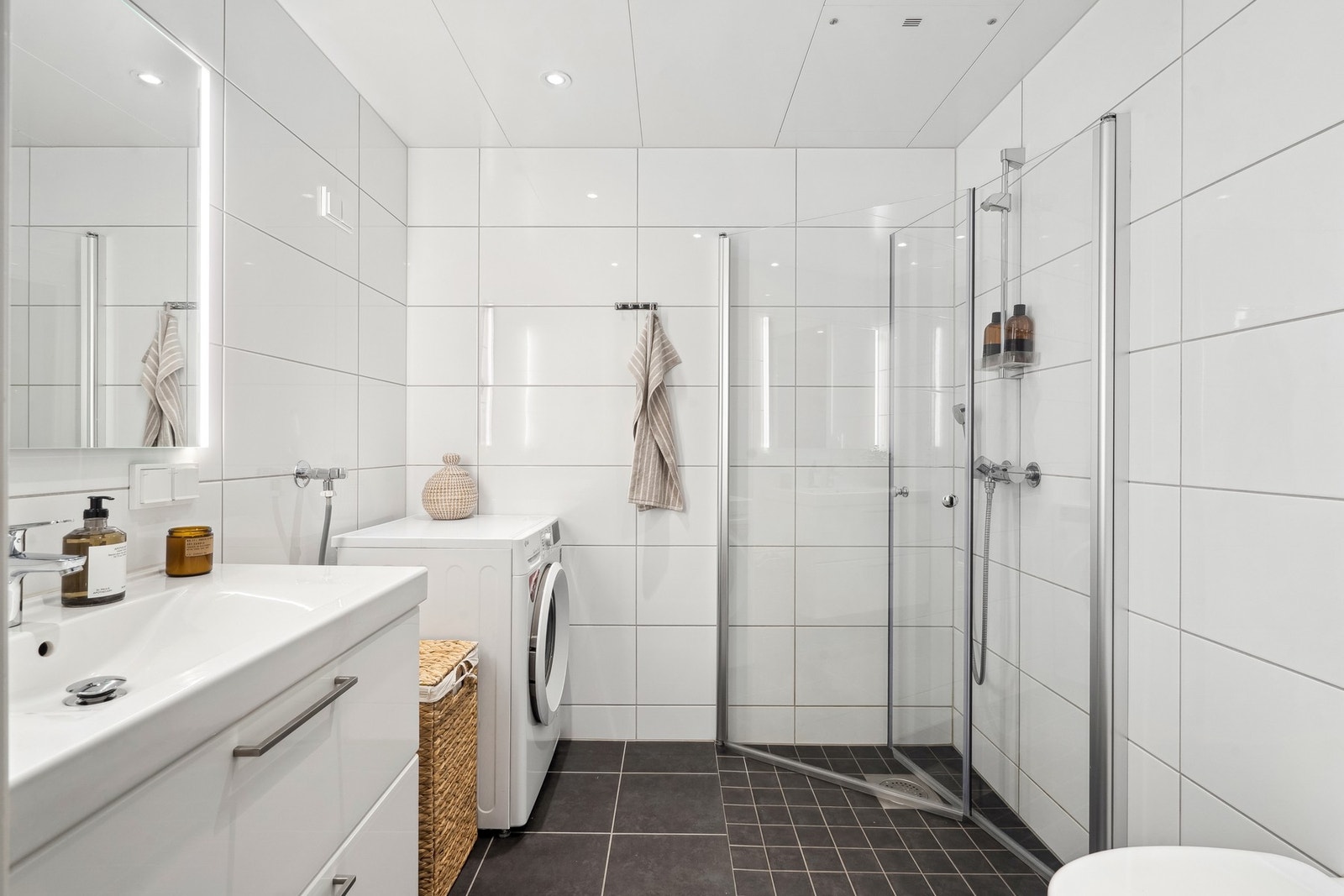 Badet er komplett flislagt i en moderne fargesammensetning. Galleribilde