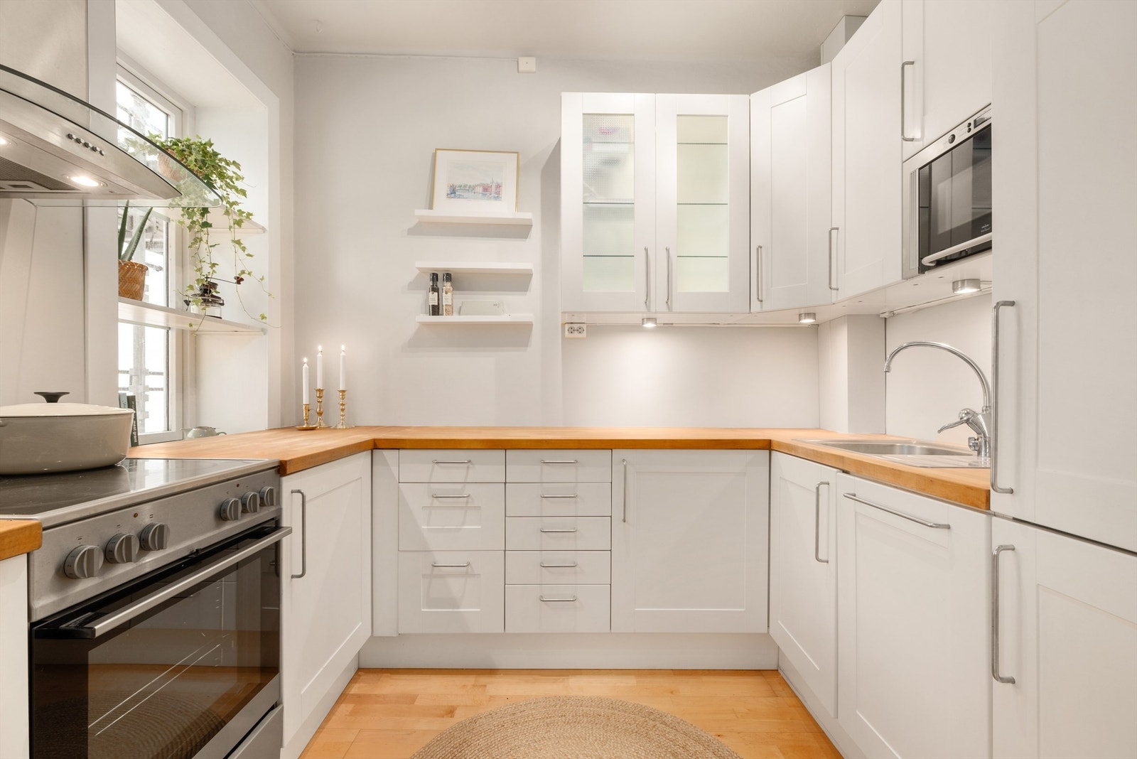 Lyst og pent kjøkken med delvis integrerte hvitevarer. Galleribilde