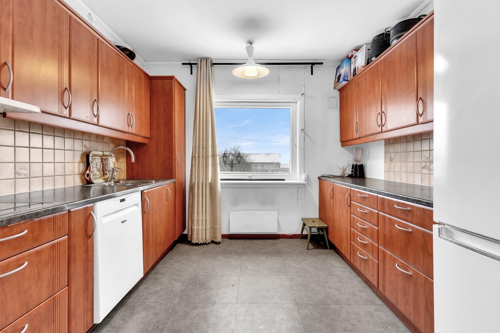 Boligen har et romslig kjøkken med slette fronter, laminert benkeplate og nedfelt oppvaskkum. Galleribilde