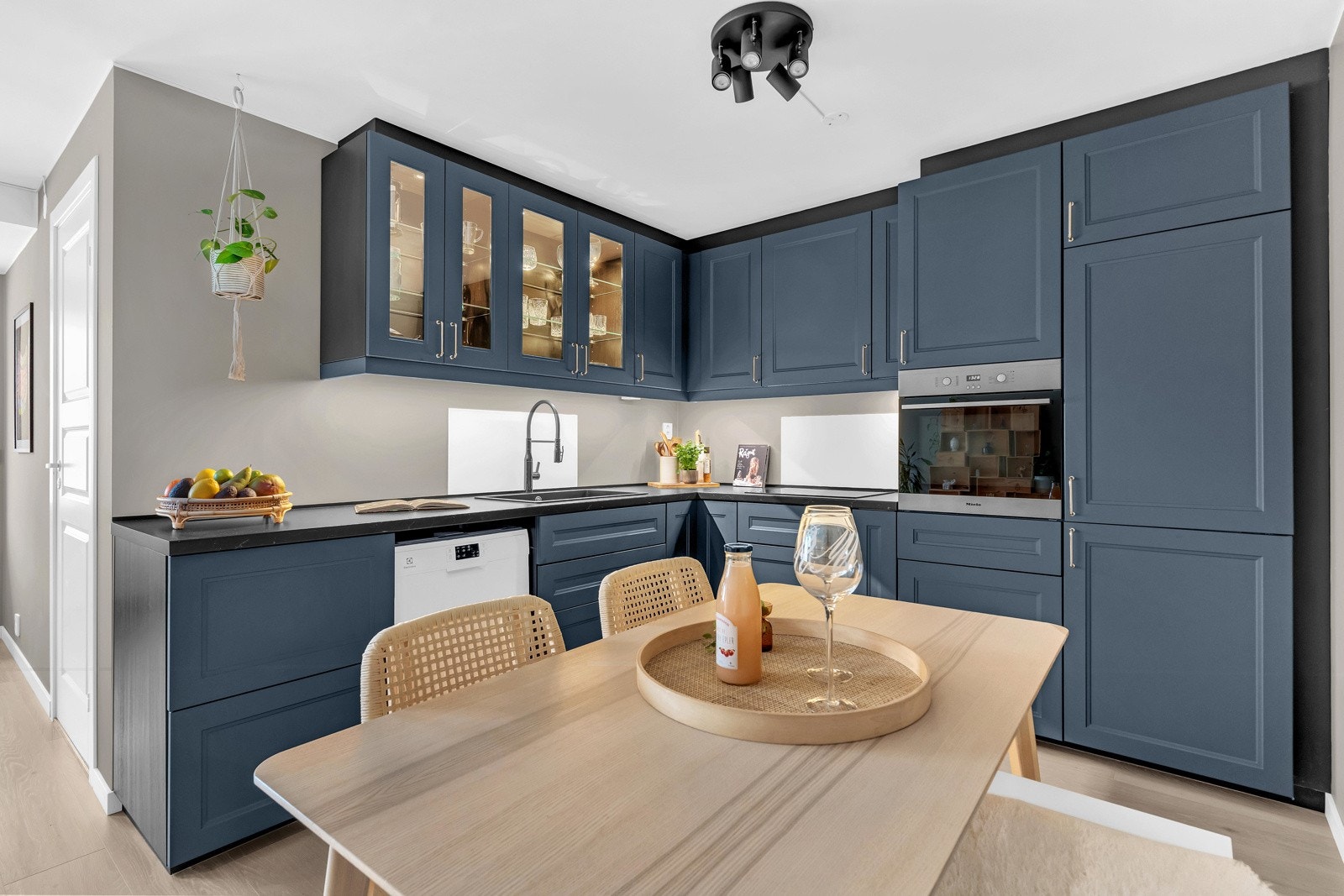 Innredet med mørkeblå profilerte flater og mørk laminert benkeplate Galleribilde