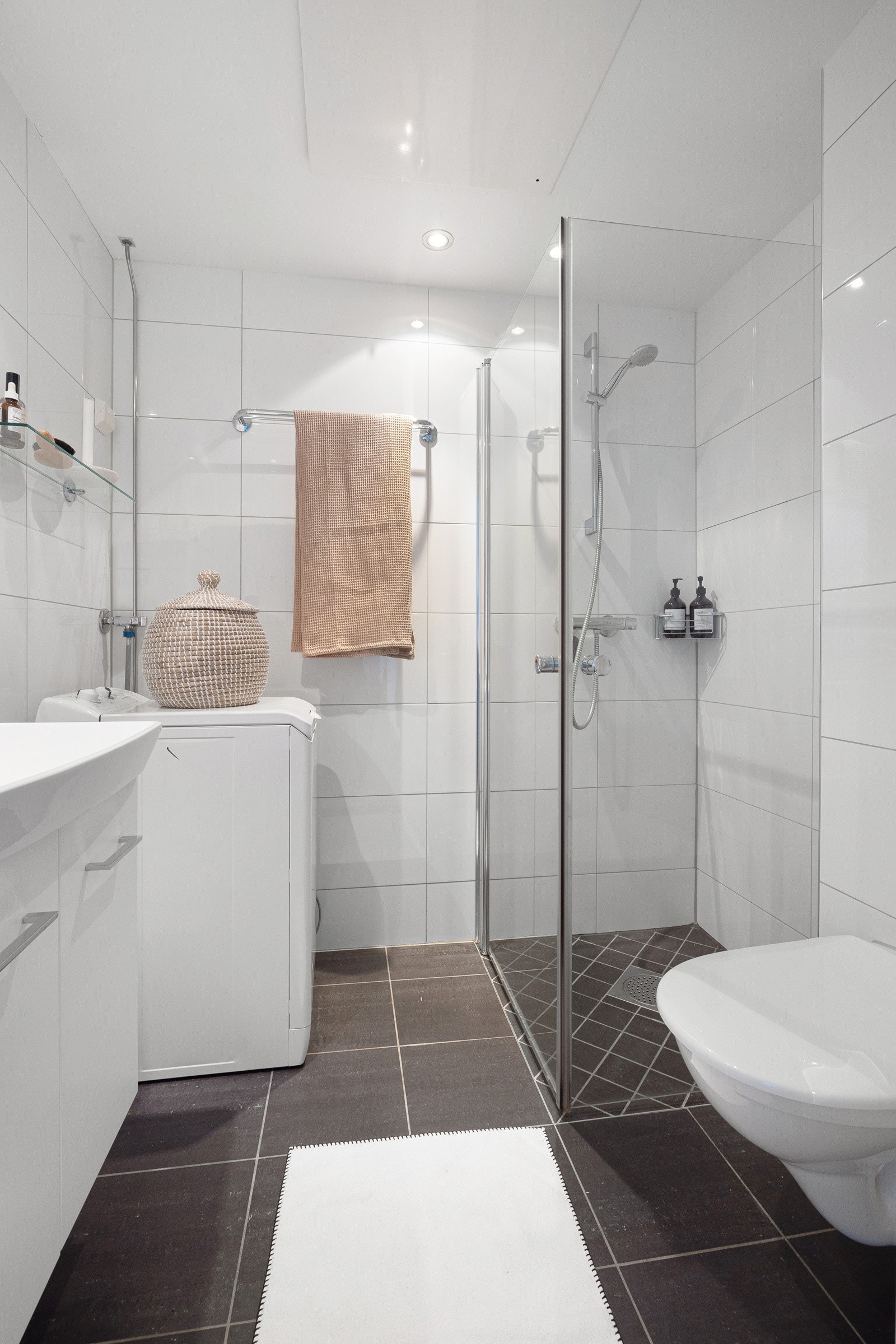 Det er utstyrt med toalett, dusjhjørne med glassdører, servantskap og opplegg for vaskemaskin. Galleribilde