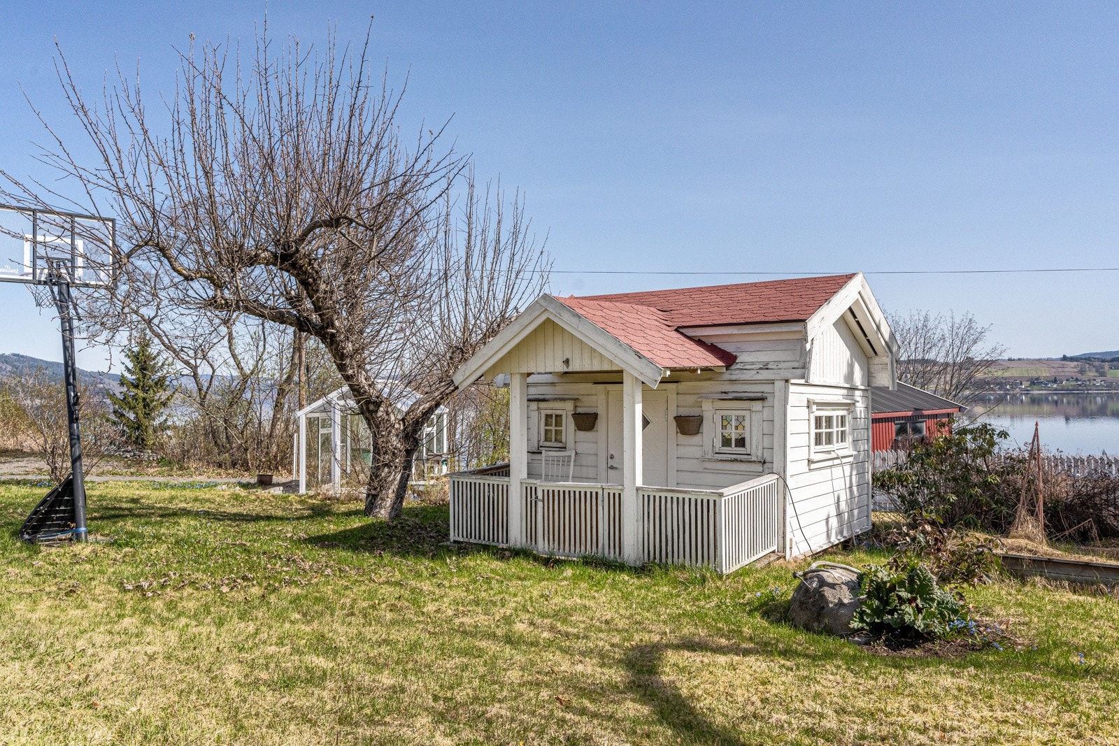 Tilhørende uthus tilbyr rikelig med lagringsplass, mens en sjarmerende lekestue og et praktisk drivhus gir rikelig med muligheter for både barn og voksne til å trives. Galleribilde