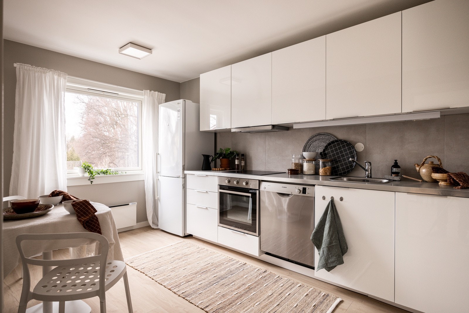 Leiligheten har et lyst og praktisk separat kjøkken. God standard med lys enstavs laminat på gulv og glatte overflater malt i en varm farge som står i fin kontrast til den lyse innredningen. Galleribilde