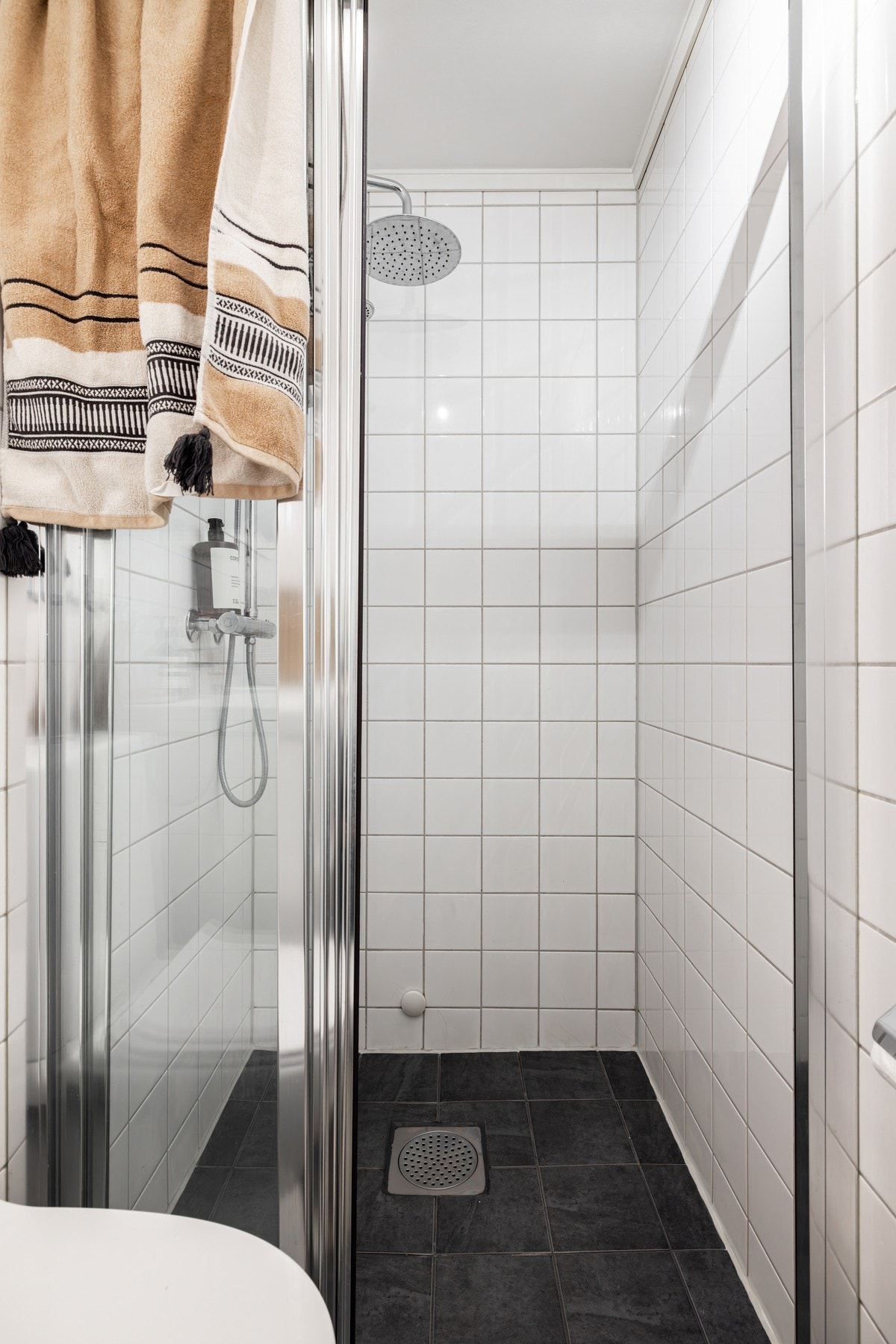 Videre er det dusjhjørne med regndusj og skillevegg. Galleribilde