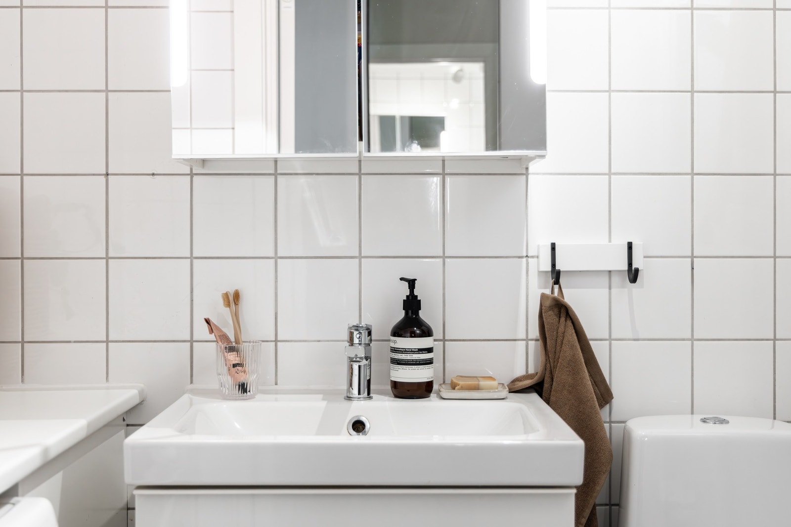 Innredningen består av servant på underskuffer, speilskap med belysning og gulvstående toalett. Galleribilde