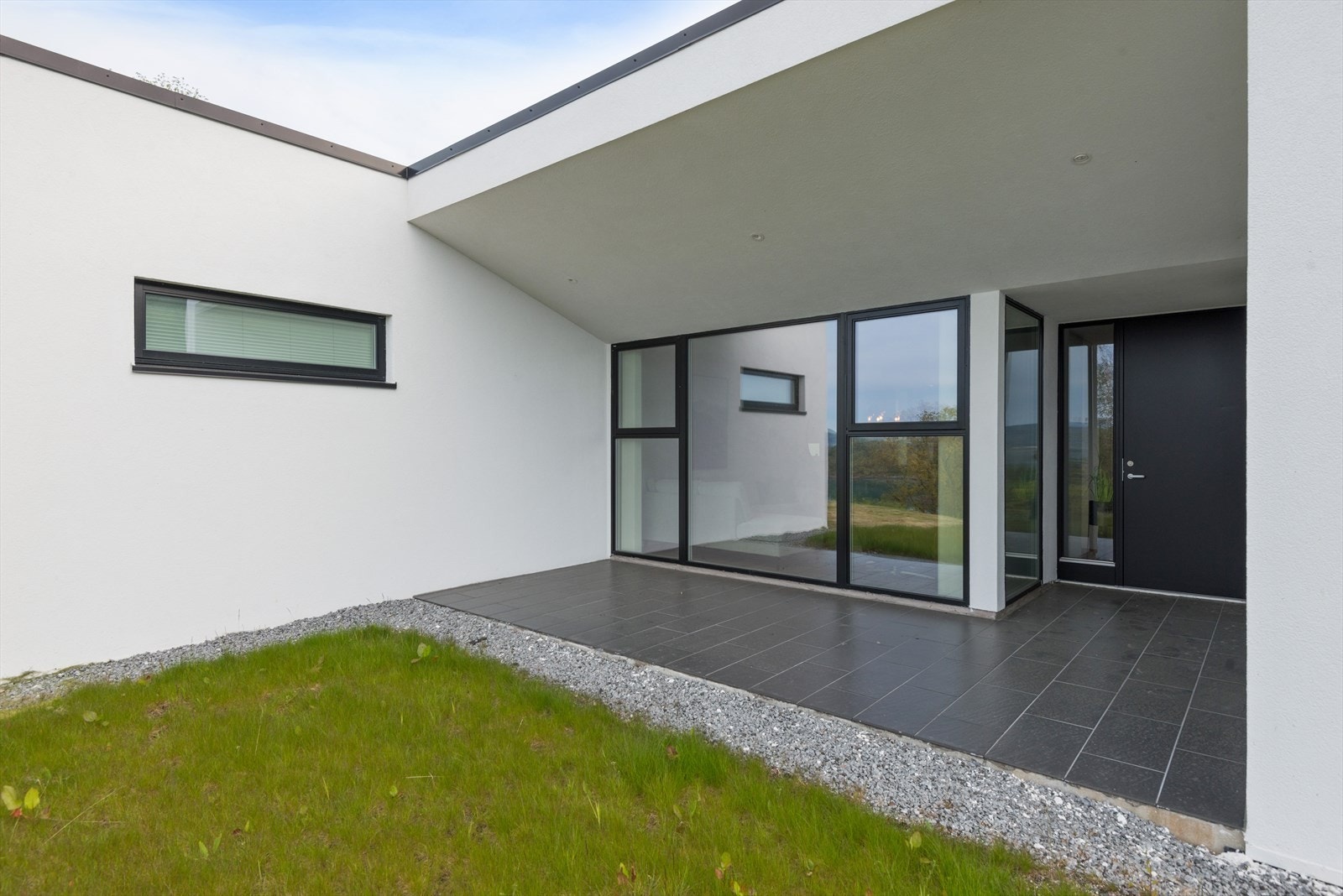 I front av huset er det eigen overbygd terrasse, samt hage. Kvar av einebustadane har eige gnr./bnr., slik at ein eig eigedommen sjølv. Bilete frå 14B. Galleribilde