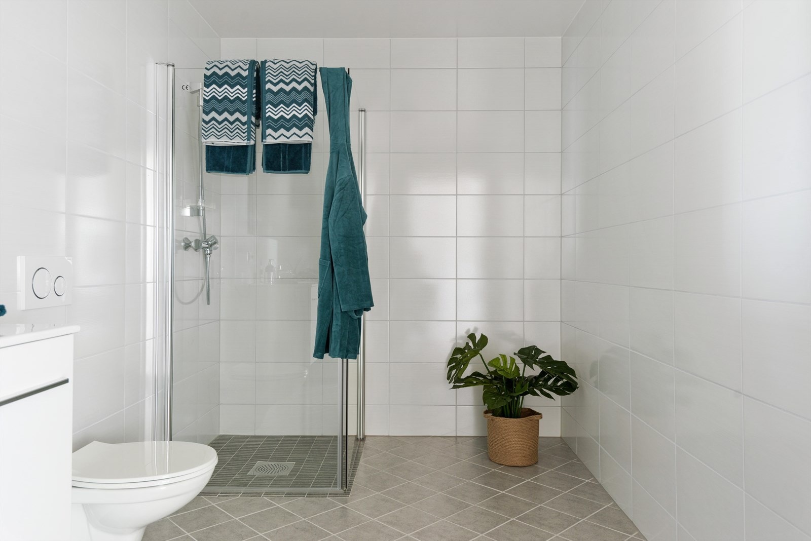Badet har servant i møbel med spegel, vegghengt toalett og dusj. Bilete frå 14B. Galleribilde