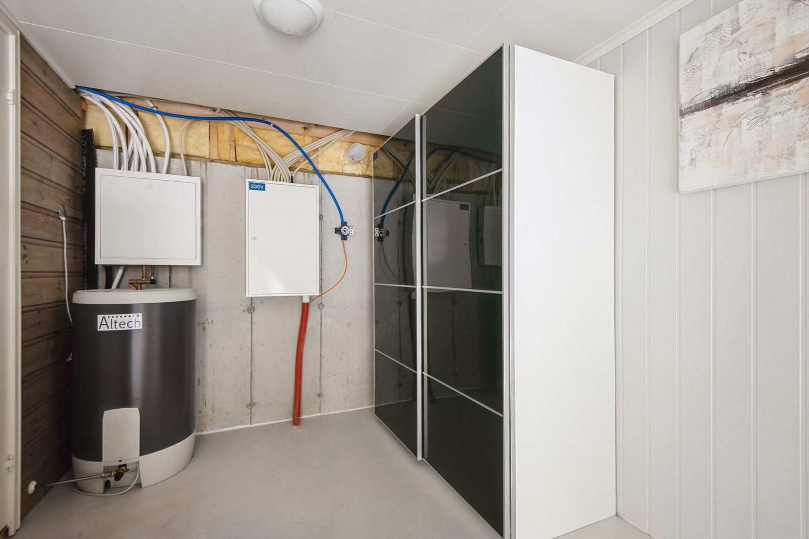 Vegg-i-vegg med badet står varmtvannstanken og sikringskapet, her er det også i dag innreia med eit stort skap. Galleribilde