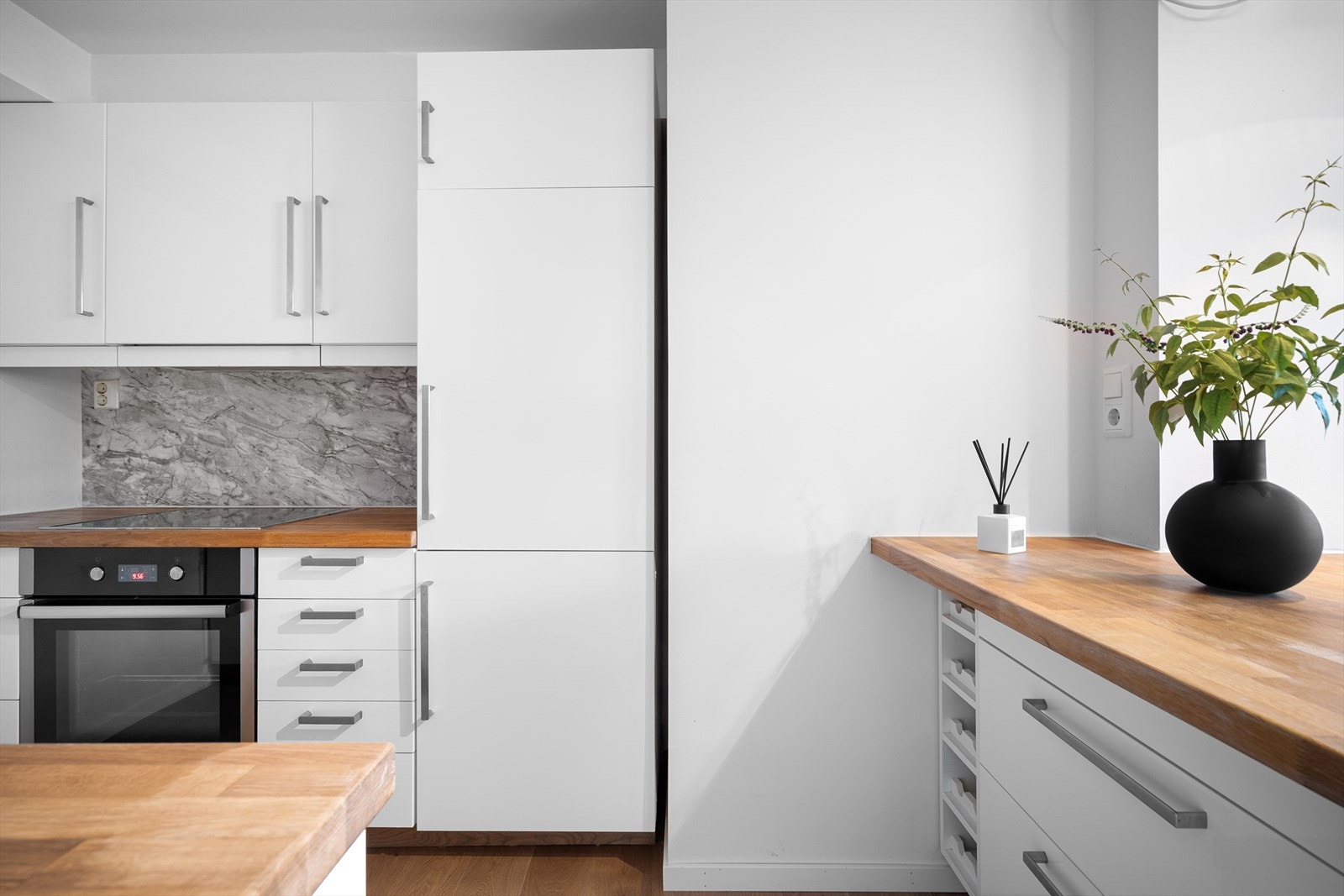 Kjøkkeninnredning med slette fronter og benkeplate i tre. Galleribilde