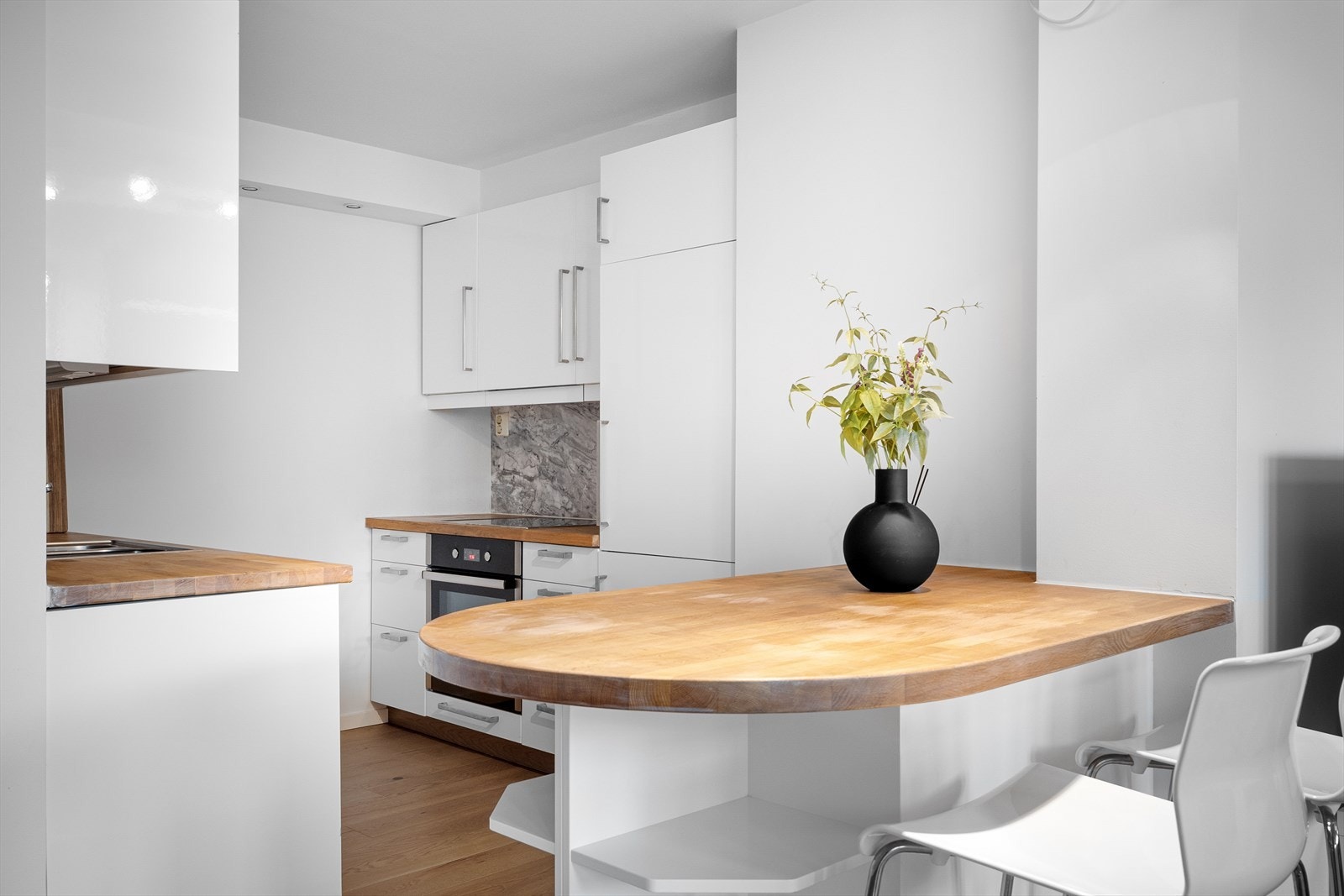 Praktisk spisebord plassert mellom kjøkkenet og stuen, noe som gir en naturlig flyt mellom sonene. Galleribilde