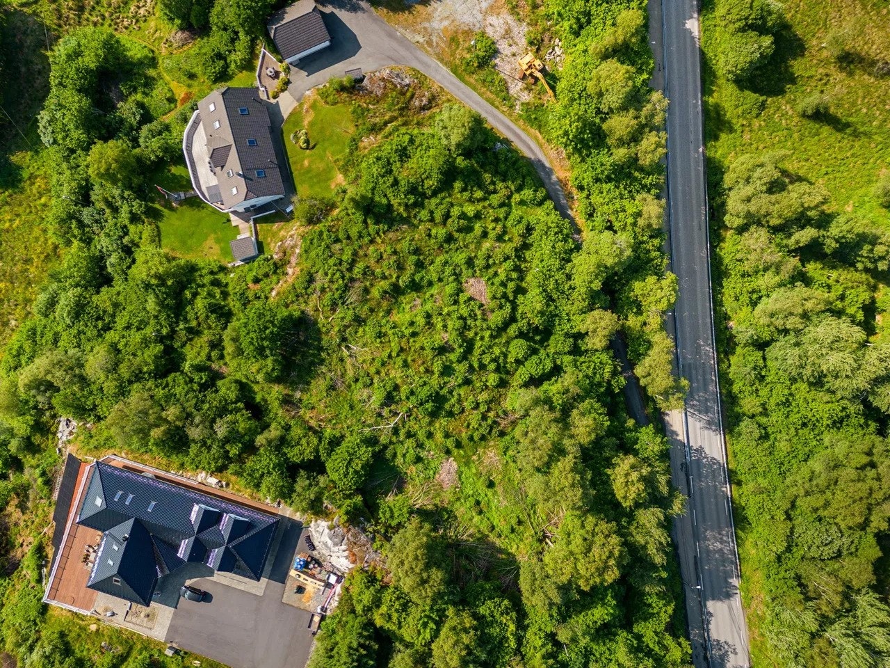 Tomten måler hele 3910,3 m² og er delvis skrånet med diverse vegetasjon. Galleribilde
