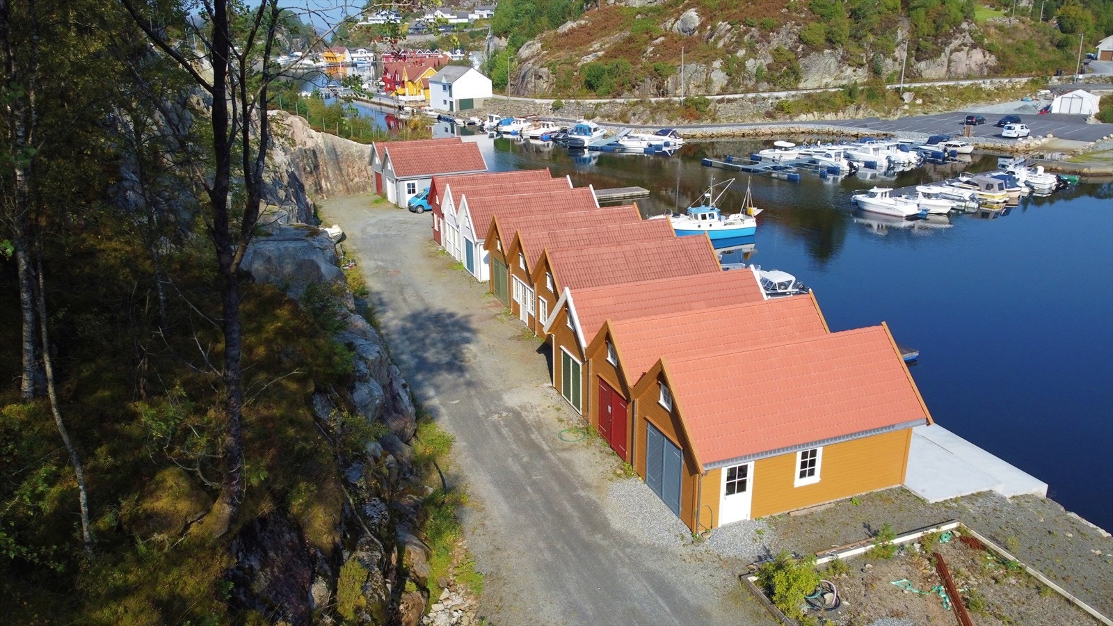 Det er køyreveg i bakkant av nausta og stor felles parkeringsplass bak dei første nausta. Galleribilde