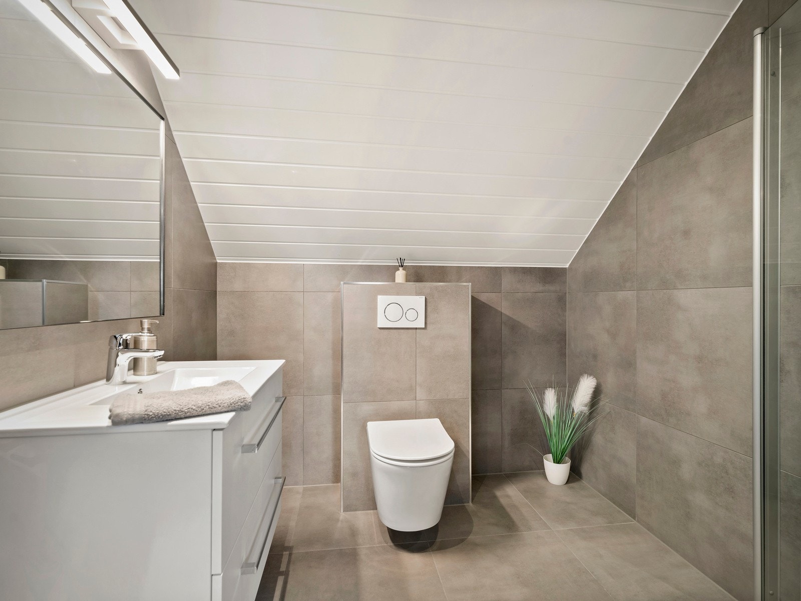 Badet i 2.etasje var oppusset i 2021 og har innredning med nedfelt servant, veggfestet toalett og dusjhjørne. Galleribilde