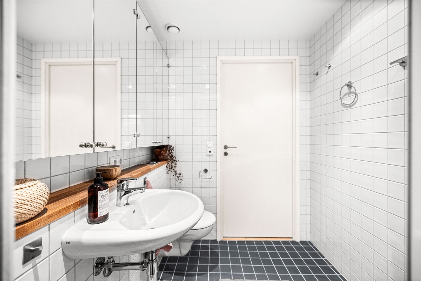 Det er speilskap på vegg samt stikkontakter og langsgående hyllekant mellom servant og speilskap. Galleribilde