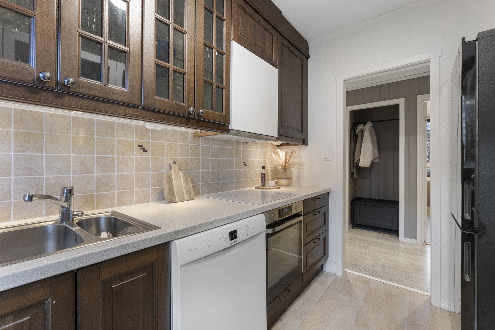 Kjøkkeninnredningen har profilerte fronter og benkeplate i laminat med nedfelt vask av stål. Galleribilde