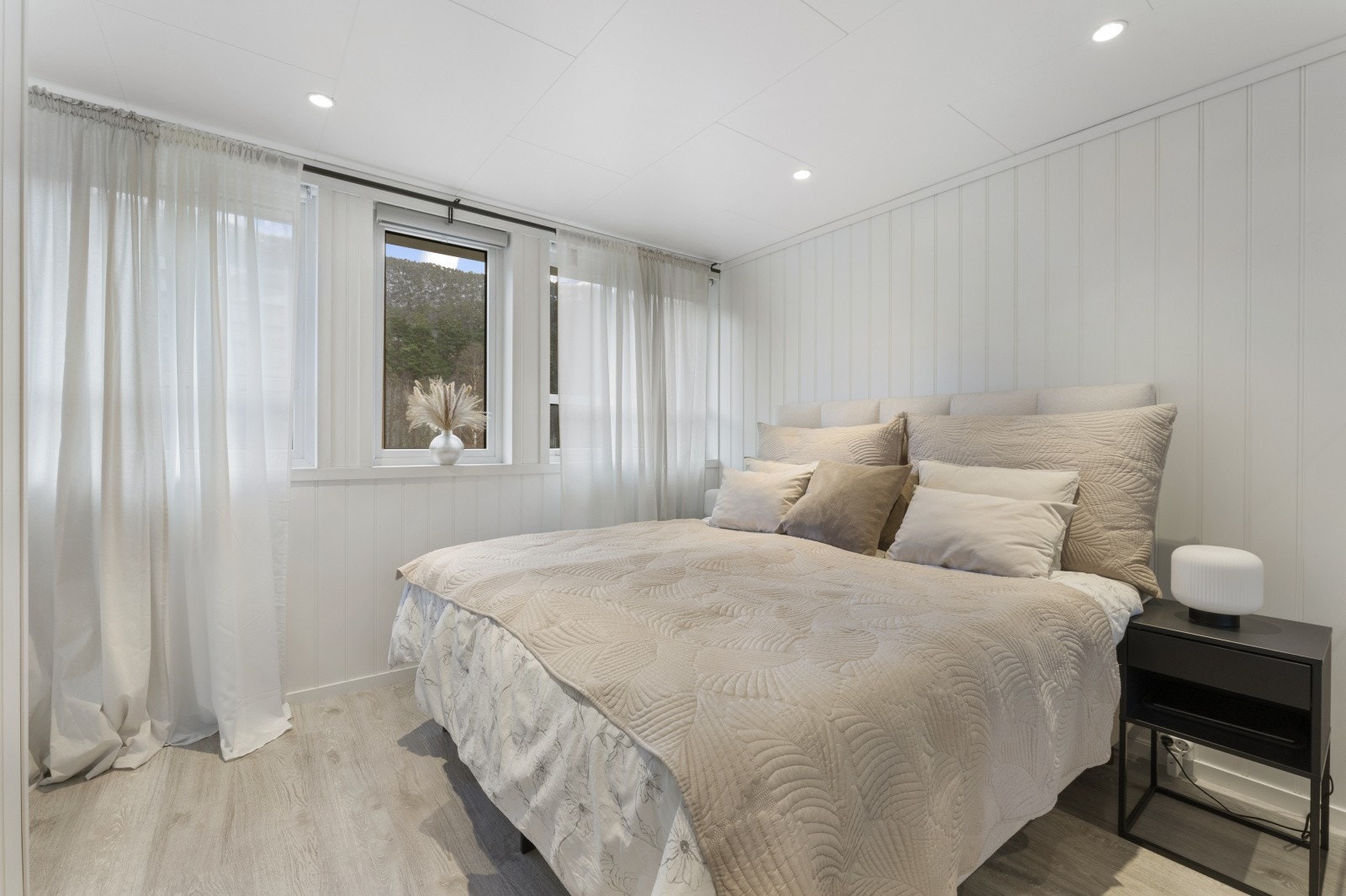 Størrelsen på rommet gir god plass til dobbeltseng og tilhørende nattbord. Soverommet er malt i en behagelig fargetone som harmonerer godt med det lyse gulvet. Galleribilde