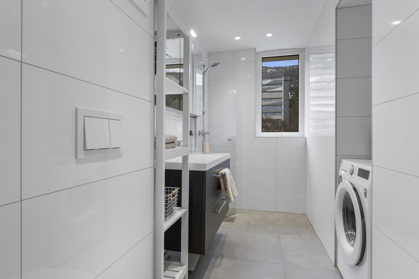 Badet er innredet med baderomsmøbel, speilskap, dusj og vegghengt toalett. Her får man et moderne bad med varmtvann inkludert i felleskostnadene. Galleribilde