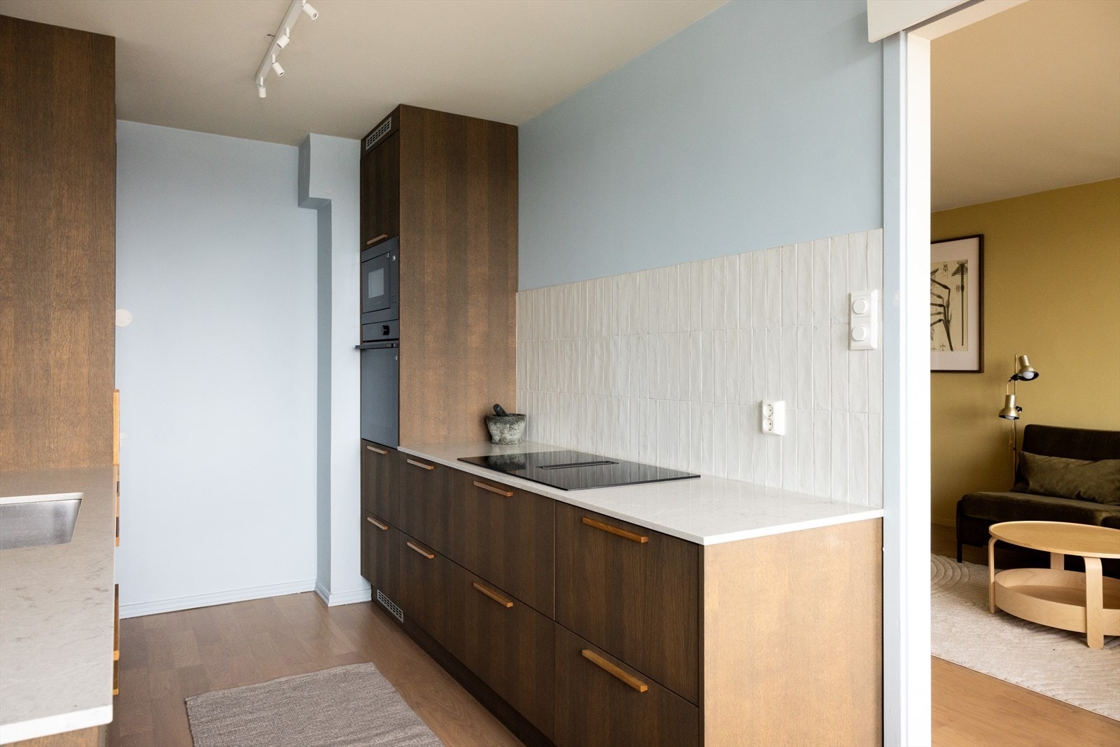 - Moderne kjøkkeninnredning med glatte fronter, benkeplate av stein med nedfelt vaskekum og fliser over benkeplaten - Galleribilde