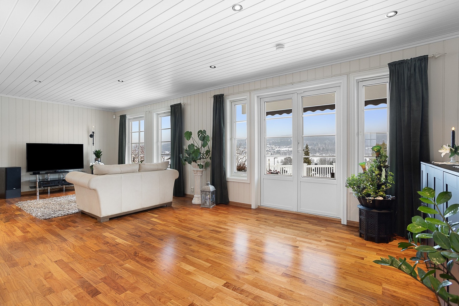 Stuen er romslig og har god plass til møblering av de komfortsonene man ønsker seg. Her er det både salong og tv-krok. Galleribilde