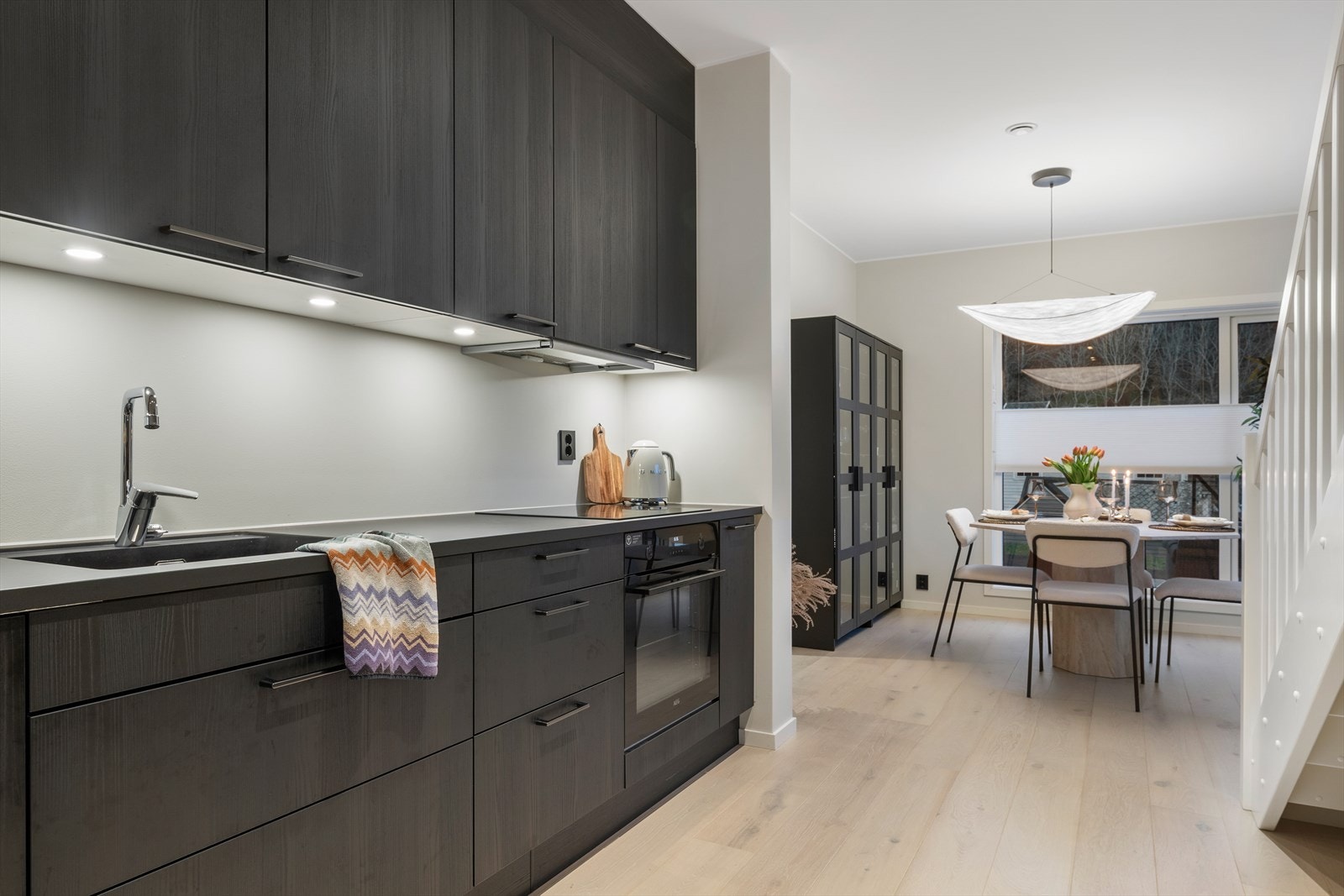 Kjøkkenet har integrerte hvitevarer som stekeovn, mikrobølgeovn, oppvaskmaskin og kjøleskap med frys Galleribilde