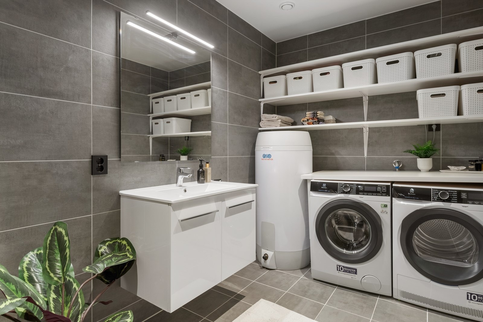 Våtrommet i andre etasje er et bad/vaskerom med moderne helflisede overflater med termostatstyrte varmekabler i gulv Galleribilde