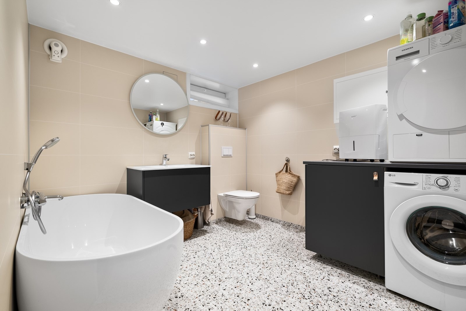 Bad/vaskerom med baderomsplater på vegger og flis på gulv med varmekabler. Galleribilde