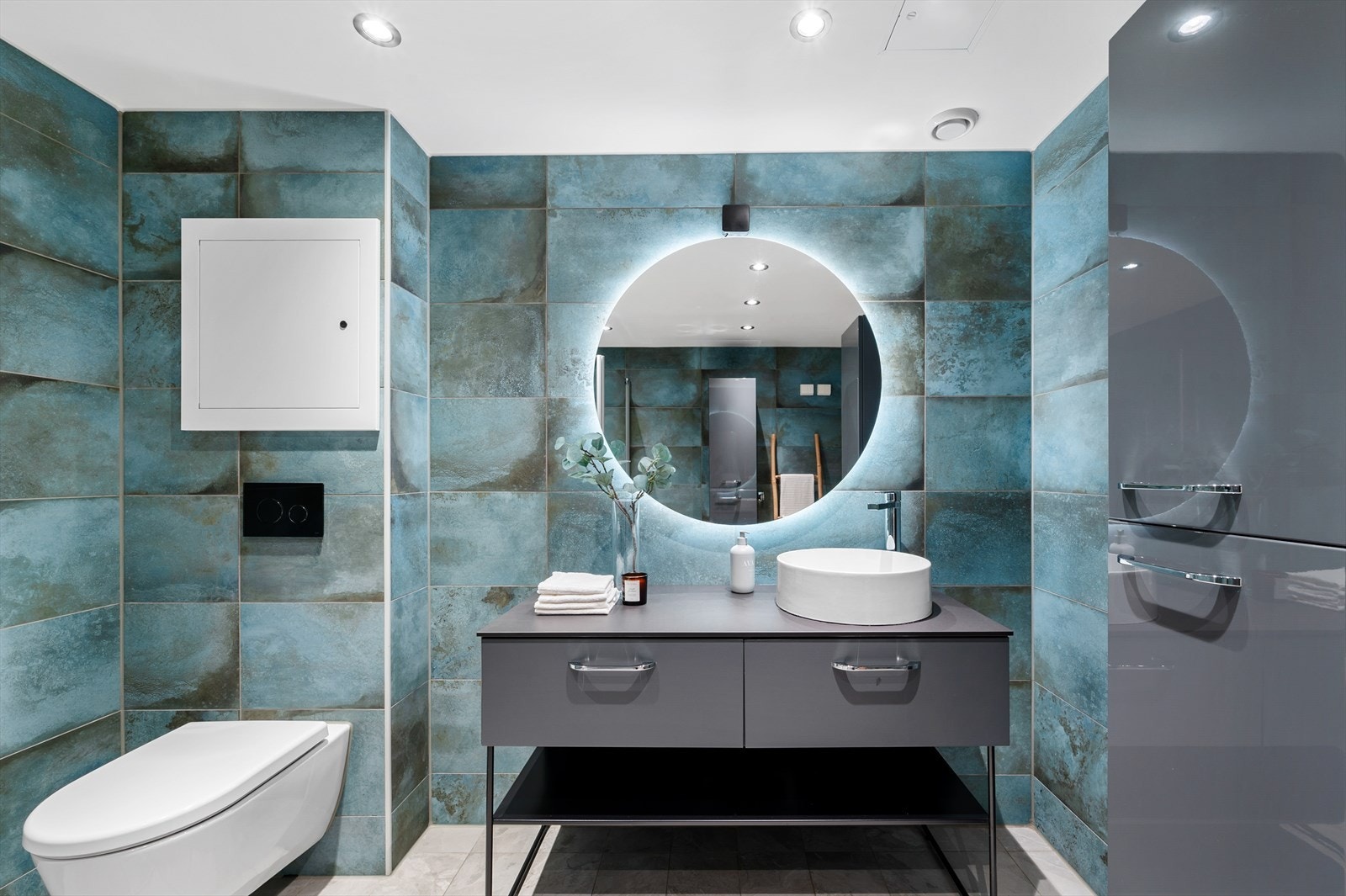 Badet har innredning med nedfelt servant, veggmontert toalett, dusjvegger/hjørne og opplegg for vaskemaskin. Galleribilde