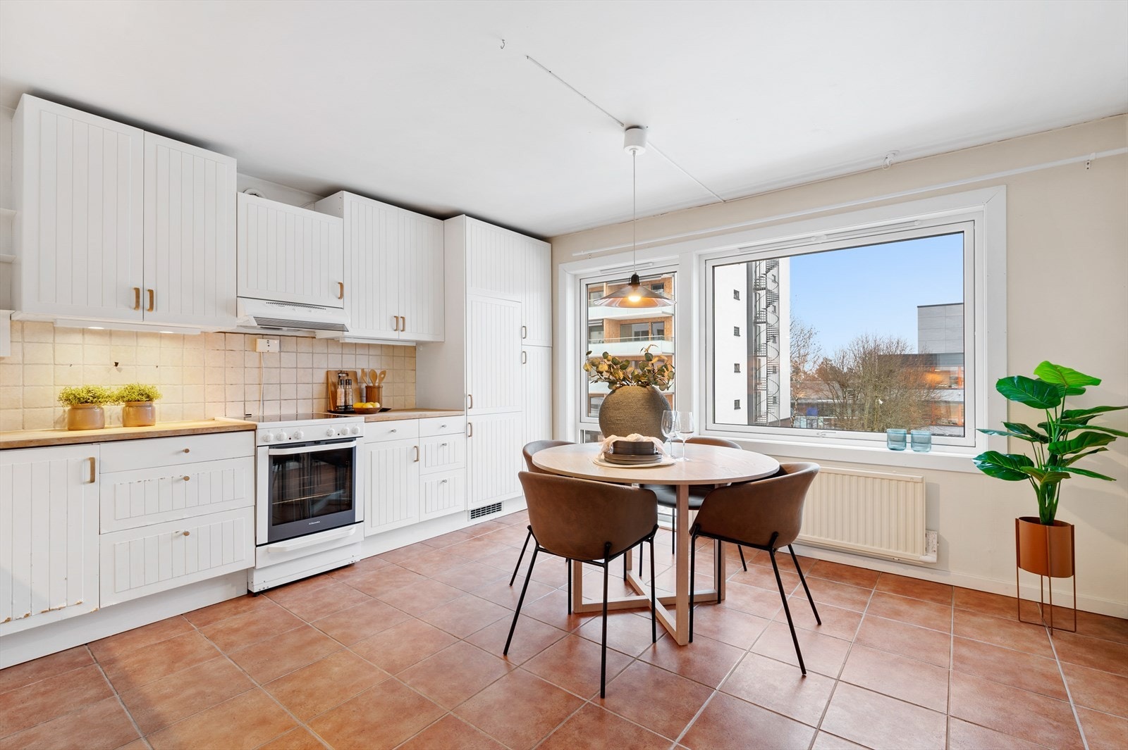 Kjøkkenet er innredet med lyse fronter og har benkeplate av heltre Galleribilde